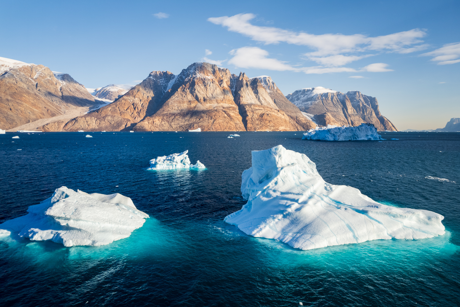 Icebergs and mountains of Øfjord in Scoresbysund.